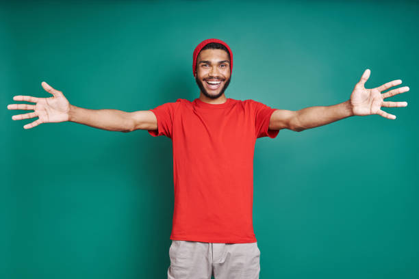 Handsome African man stretching out hands and smiling stock photo