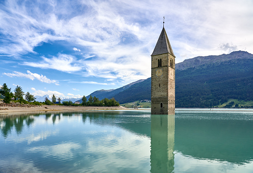 Chiesa di Santa Caterina d'Alessandria's bell tower submerged in Lago di Resia.  The church nave was demolished in 1950 when the artificial lake was created. Reschensee in German and Lago din Resia in Italian.\n Bolzano Province, Trentino Alto-Adige