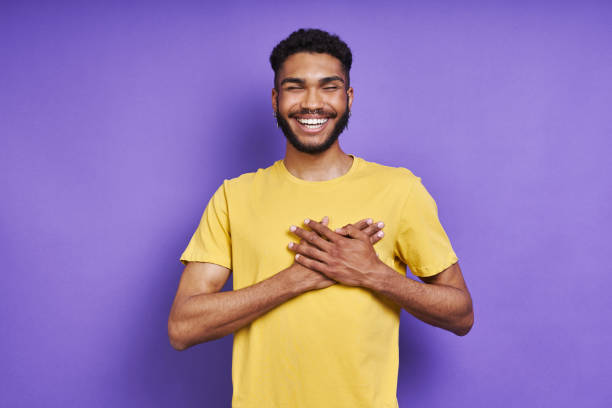 istock Thankful African man holding hands on heart and smiling 1406514137
