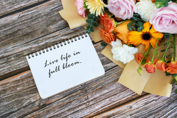 istock Note pad with text live life in full bloom with mixed flower bouquet 1406514317