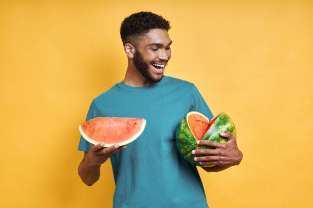 istock Handsome African man holding watermelon and smiling 1406515476