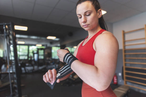 istock Young woman adjusting wrist wrap in gym 1406516757