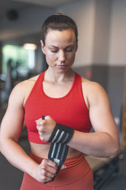 istock Young woman put on wrist wrap in gym 1406517272