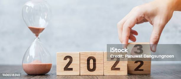 Hand Flip Block 2022 To 2023 Text With Hourglass On Table Resolution Time Plan Goal Motivation Reboot Countdown And New Year Holiday Concepts Stock Photo - Download Image Now