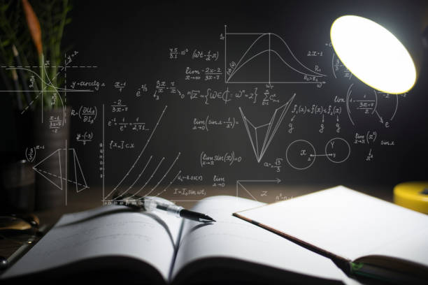 istock Reading table at night, Open books on the table, Close-up the pen tip, With mathematical formulas. 1406518392