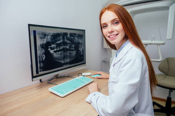 istock redhaired ginger female dentist showing mouth x-ray on computer 1406519387