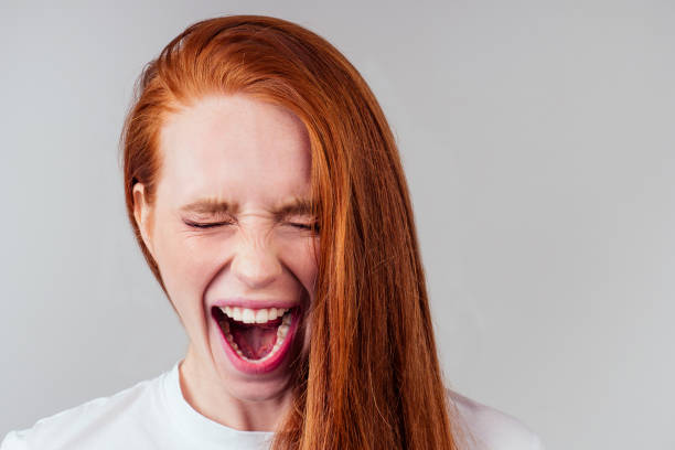 istock redhaired ginger student woman with open mouth and bad teeth. 1406519496