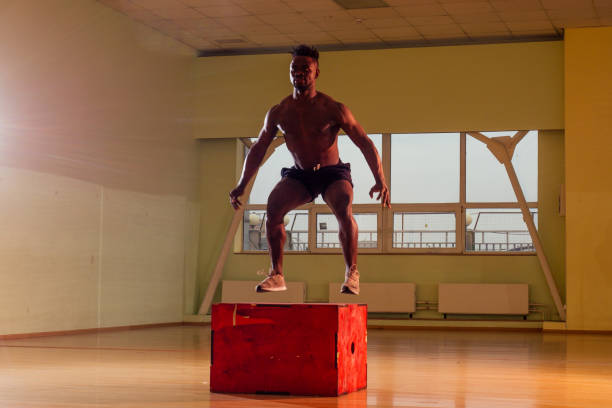 istock afro man doing exercise with a fit box in a gym 1406519605