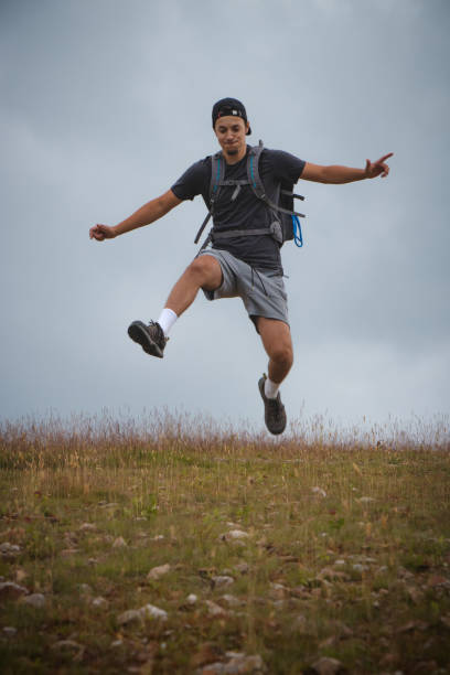 istock Swarthier type of man is running down a gravel hill, checking his every step to avoid injury. Active athlete runs over challenging terrain to improve fitness, coordination and precision of movement 1406519994