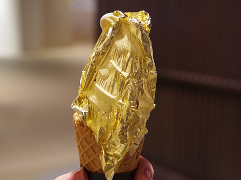 Ishikawa,Japan August 9, 2020:This is a soft serve ice cream with gold leaf on it.Kanazawa City, Ishikawa Prefecture, Japan is famous for producing gold leaf.It has a long history, and there is a book that the Kaga domain ordered the production of gold and silver leaf in 1593. Kanazawa is blessed with water quality and climate suitable for foil production.The soft water quality of Kanazawa is suitable. In addition, Kanazawa has a lot of humidity, so the dampness of the paper is suitable. Kanazawa now produces almost all of Japan's gold leaf.