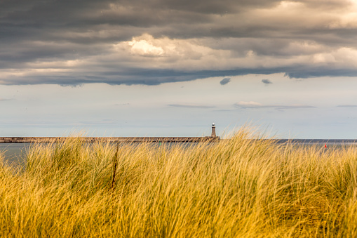 The old, red, wooden Herd Groyne Lighthouse in South Shields, stands out against the cloudy sky, England