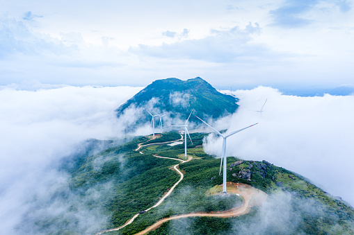 High mountains, sea of clouds and wind turbines