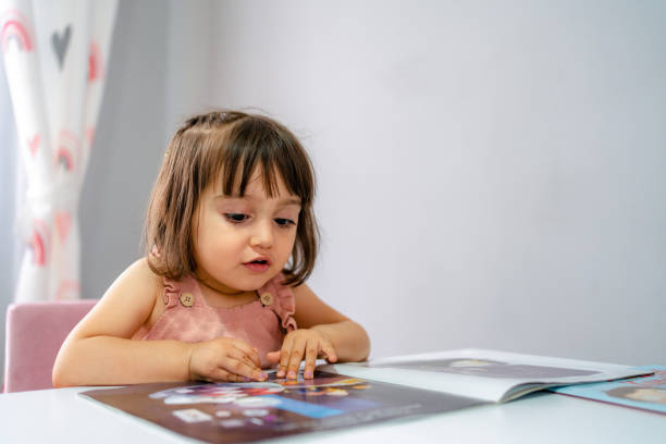 istock Little girl reading a book 1406525975