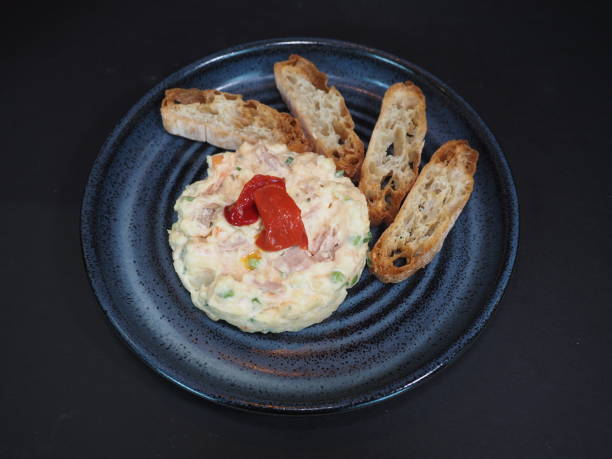 insalata di patate spagnola con pane servita in un piatto isolato su sfondo scuro vista dall'alto - prepared tuna foto e immagini stock