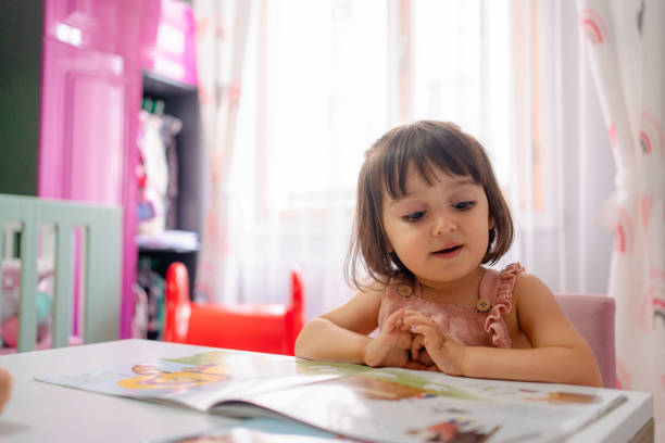 маленькая девочка, чтение книги - child contemplation thinking little girls стоковые фото и изображения