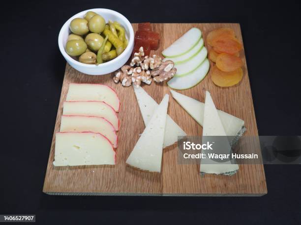 Assorted Cheese Platter Served In A Wooden Board Isolated On Dark Background Top View Stock Photo - Download Image Now