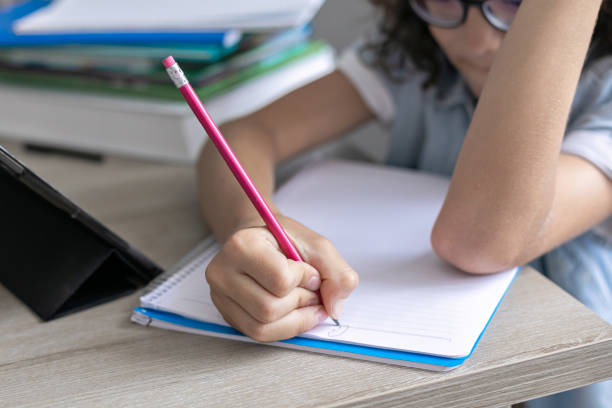istock Little adorable school boy with eyeglasses, studying online from home. kid using digital tablet 1406528627
