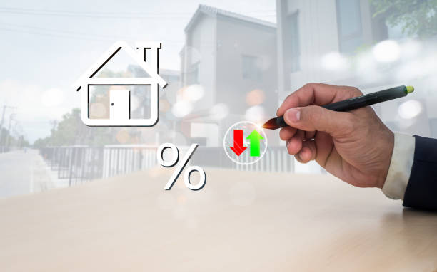 la penna dell'uomo indica un simbolo di casa sullo schermo versuale. la nozione di pagamento e riduzione del mutuo per la casa, calcolo degli interessi, tassazione, risparmio e pianificazione. - interest rate percentage sign moving down sadness foto e immagini stock