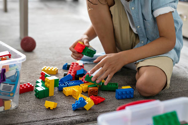 istock Little toddler boy playing with colorful plastic blocks at home building creative game, imagination 1406530673