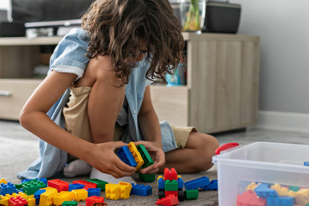 istock Little toddler boy playing with colorful plastic blocks at home building creative game, imagination 1406530703