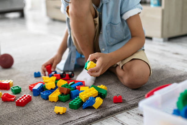 istock Little toddler boy playing with colorful plastic blocks at home building creative game, imagination 1406530717
