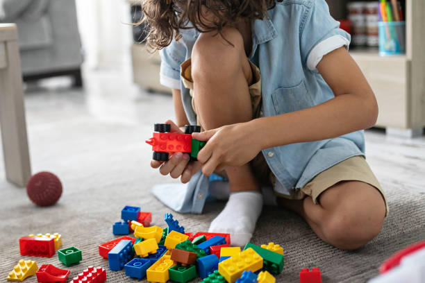 istock Little toddler boy playing with colorful plastic blocks at home building creative game, imagination 1406530766