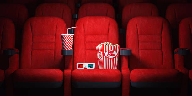 Red cinema seats and cola, popcorn and glasses in empty theater. Cinema movie theater concept background. stock photo