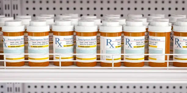 Photo of Row of drug bottles and pill tablet box on the farmacy shelf.