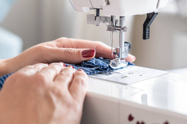 istock woman hands close up sewing on machine stitching fabric material 1406531753