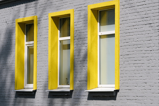 Architectural facade of an administrative building with yellow windows on a summer sunny day