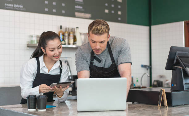 istock Cafe Owner and barista checking online order from customer on computer tablet at coffee.Small business concept 1406533580