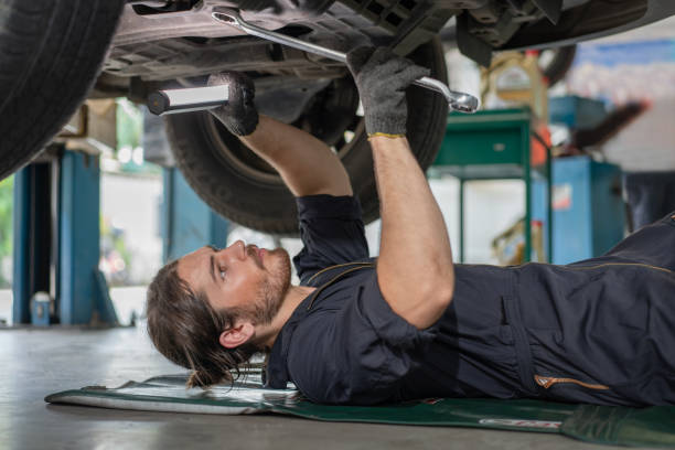 istock Mechanics man using flashlight with wrench tool in hand for fix and maintenance car lying down under the car at auto service garage 1406533692