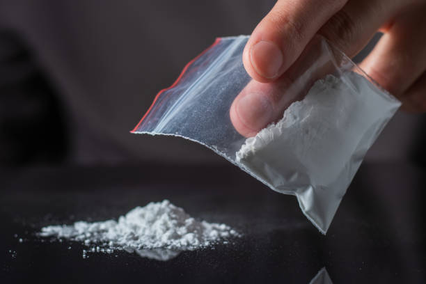 Concept drug addiction. Man hand holds plastic packet or bag with cocaine or another drugs Concept drug addiction. Man hand holds plastic packet or bag with cocaine or another drugs, drug abuse and danger addiction concept. wrongful death stock pictures, royalty-free photos & images