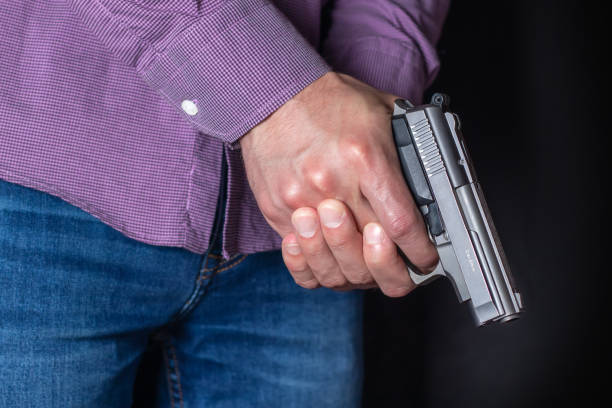 istock Gun control concept. Armed man holds pistol in hand 1406537819