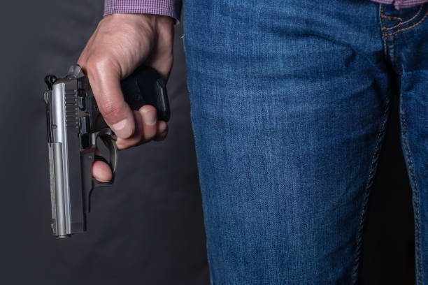 istock Gun control concept. Armed man holds pistol in hand 1406540519