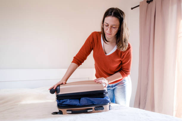 istock Young woman preparing suitcase for travel 1406540709