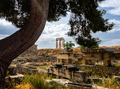 Ruins of ancient city of Corinth and Temple of Apollo at on summer cloudy day. Famous destination of Peloponnese peninsula both for history of Ancient Greece and christianity, place of St Paul preaching.