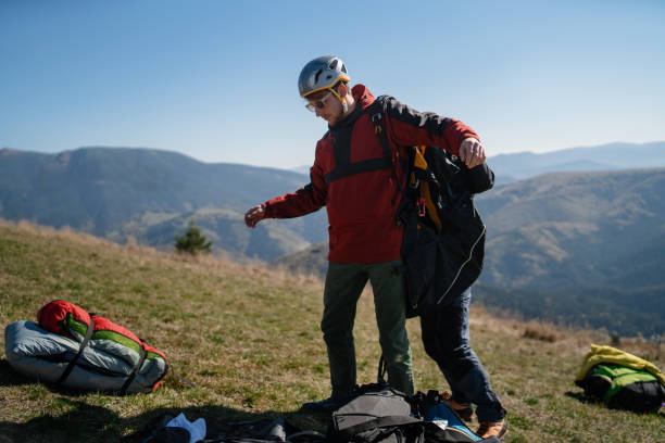 istock Man helping paragliding pilot to prepare for flight. 1406541784