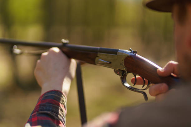 istock Hunter man aiming with rifle gun on prey in forest. 1406543330
