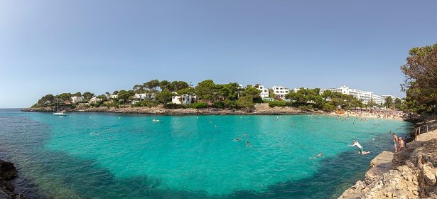 Cala D'or, Spain June 22, 2022: PEOPLE ENJOY THE scenic beach at Cala D'or at the island of Mallorca, Spain