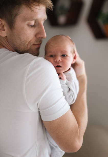 istock Father holding his newborn son at home. 1406546882