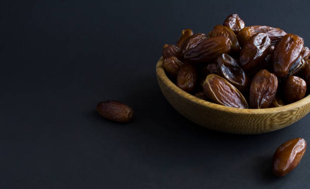 istock Dates in the bowl on the black background. Close-up. Copy space. 1406546901