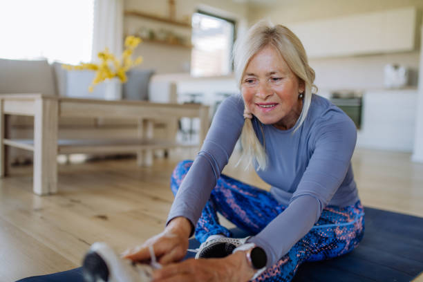istock Fit senior woman doing stretching exercise at home, active lifestyle concept. 1406547901