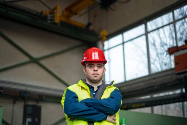 istock Young man with Down syndrome working in industrial factory, social integration concept. 1406549721