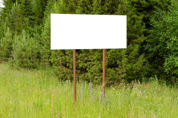 istock A white empty billboard in the forest among the trees. Summer, copy space. 1406552350