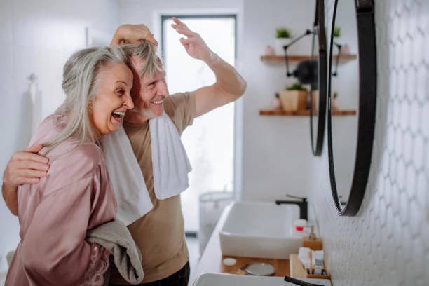 istock Senior couple in bathroom having fun, brushing teeth and washing, morning routine concept. 1406553163