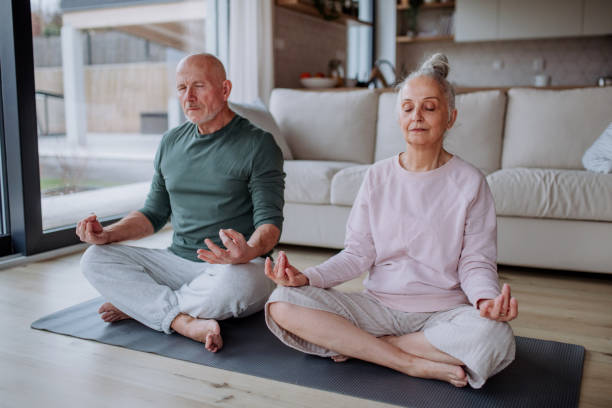 istock Senior couple doing relaxation exercise together at home. 1406553243