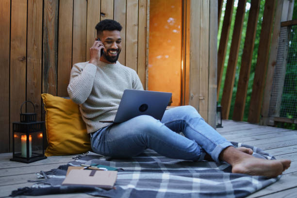 istock Happy young man with laptop resting outdoors in a tree house, weekend away and remote office concept. 1406553778