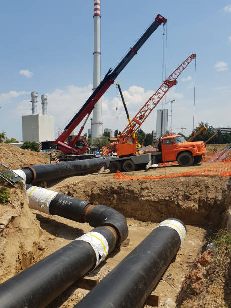 istock Laying heating pipes in a trench at construction site. 1406554480