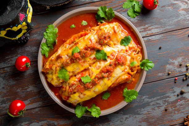 Enchilada with beef with tomato sauce on wooden table, mexican kitchen top view Enchilada with beef with tomato sauce on wooden table, mexican kitchen top view enchilada stock pictures, royalty-free photos & images